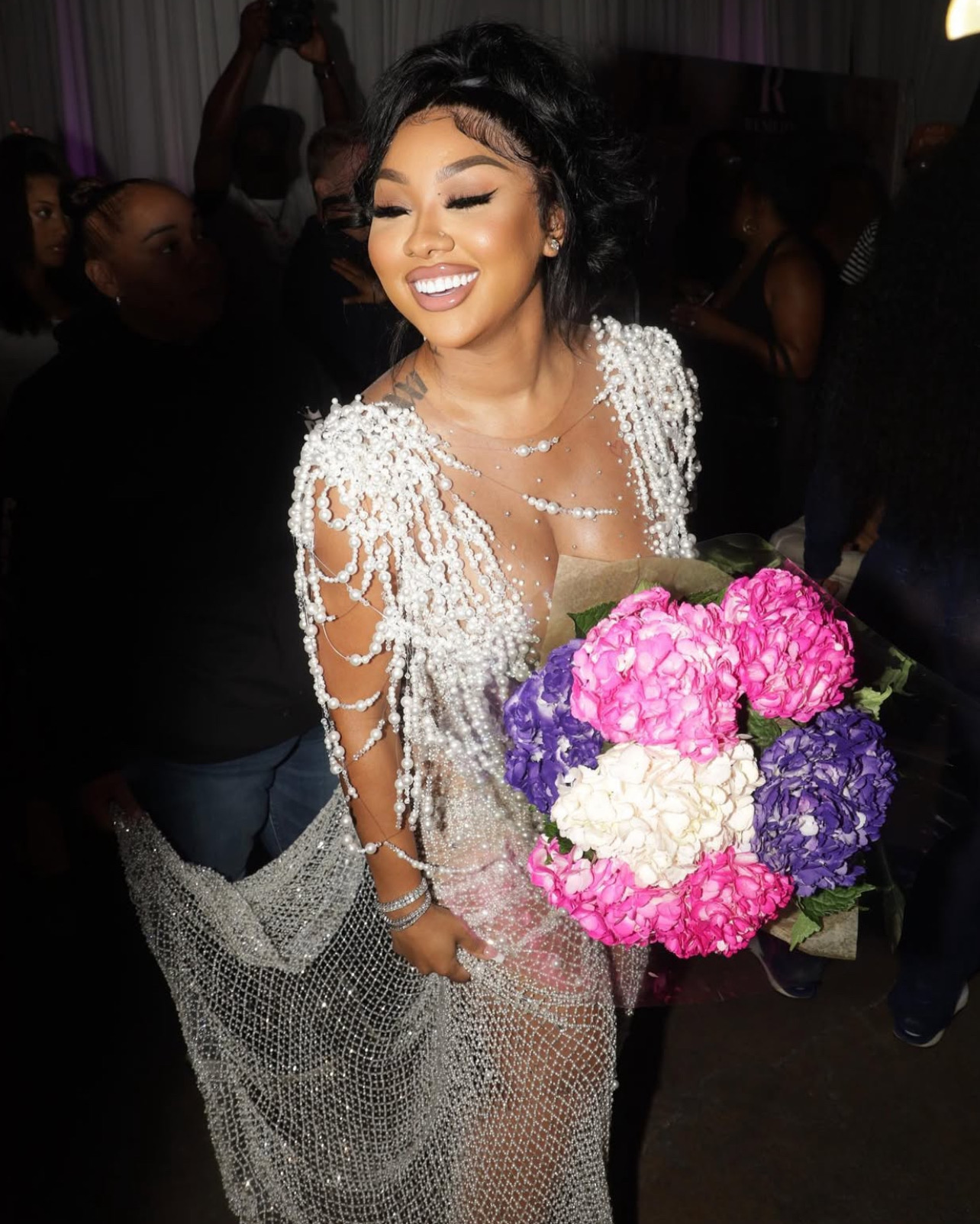 Woman in a sparkling silver dress holding flowers