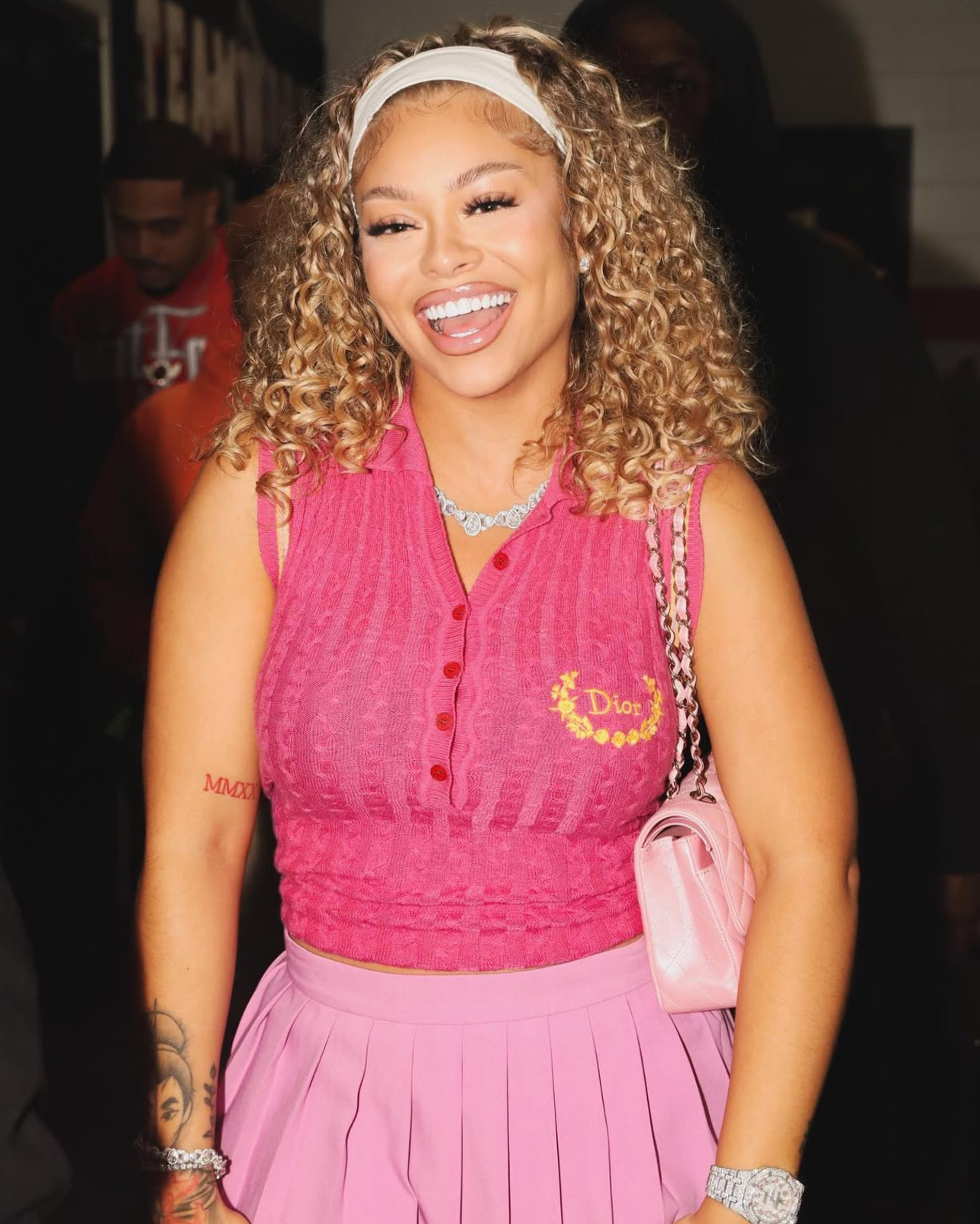 Woman in a pink outfit smiling at an event