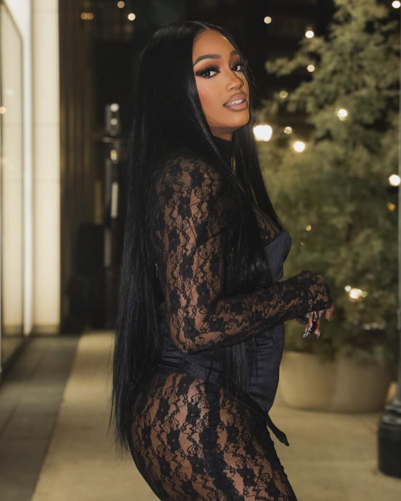 Woman in a black lace outfit photographed at night