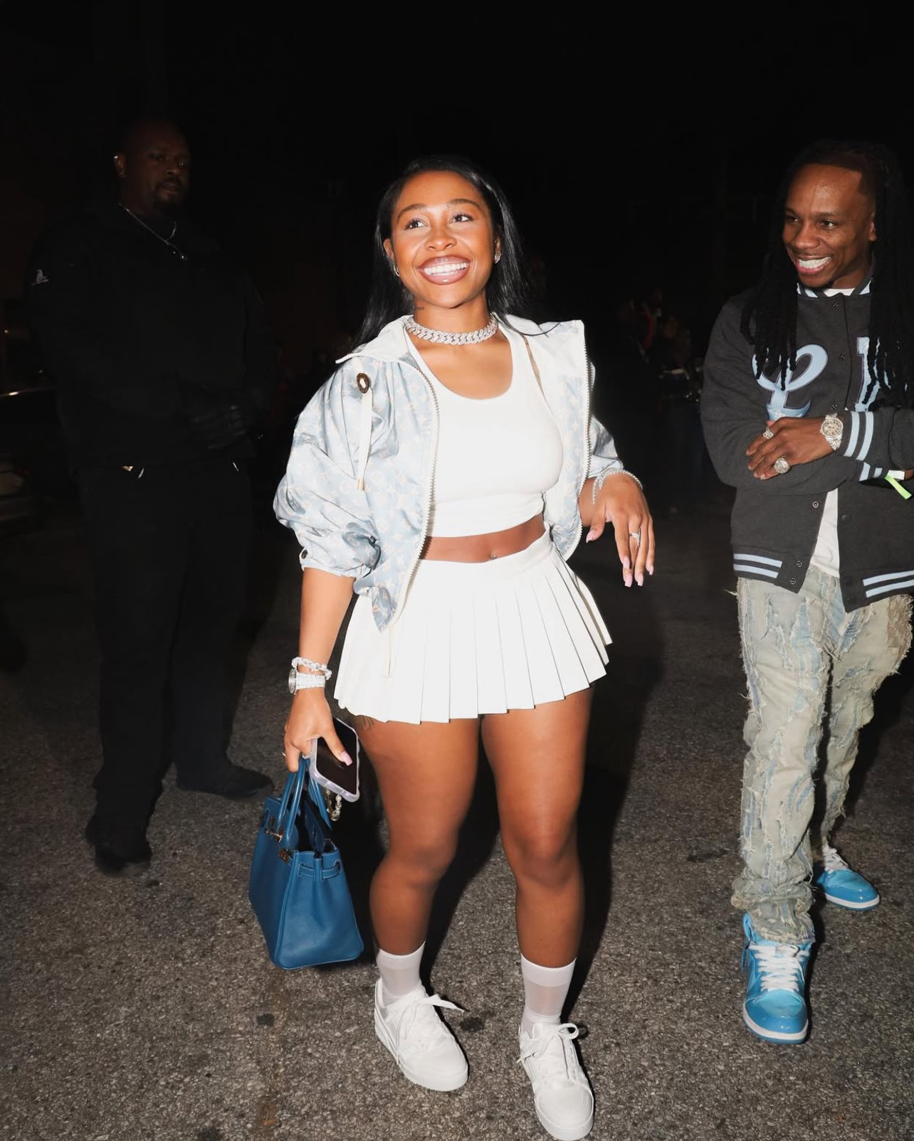 Woman in a white outfit walking at a night event